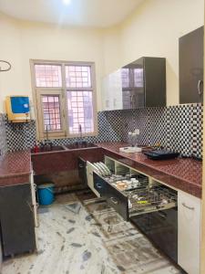 a kitchen with a counter with a sink and a counter at Om Homestay in Panchkula