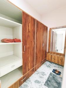 a room with wooden cabinets and a mirror at Om Homestay in Panchkula
