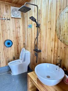 a wooden bathroom with a toilet and a sink at Dốc Mơ Homestay in Bản Bé