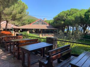 a row of wooden tables and benches in a park at Montazah Residence in Dar el Koudia
