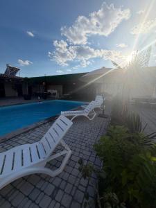a group of white lounge chairs next to a swimming pool at Events house With Swimming Pool in Agarak