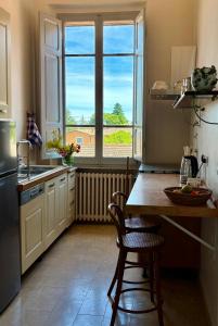 a kitchen with a table and a large window at Le Finestre in Città della Pieve