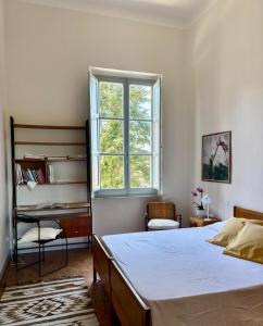 a bedroom with a bed and a desk and a window at Le Finestre in Città della Pieve