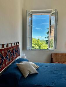 a bedroom with a blue bed and a window at Le Finestre in Città della Pieve