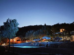 a swimming pool with umbrellas and tables and chairs at Tramontana Glamping in Bar +26 photos