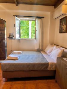 a bedroom with a large bed with a window at Sofia Apartments- Melidoni in Melidhónion