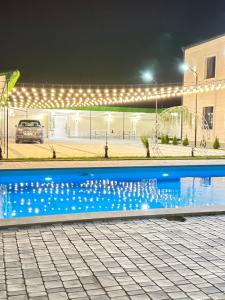 a swimming pool with lights around a building at Events house With Swimming Pool in Agarak