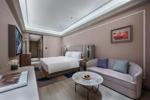 a hotel room with a bed and a couch at Mercure Beijing Lize Road in Beijing