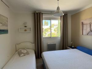 a bedroom with two beds and a window at 50 pas de l'Ô in Saint-Cyr-sur-Mer +33 photos