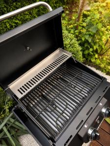 a grill sitting on a table in a yard at Garden Spa Suite - Private Sauna & Whirlpool in Betzdorf