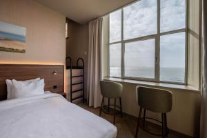 a hotel room with a bed and a large window at Hotel De Zeevaartschool in Vlissingen +86 photos