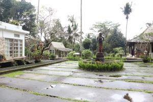 a statue in the middle of a courtyard at Aventus Resort Ubud in Tegalalang