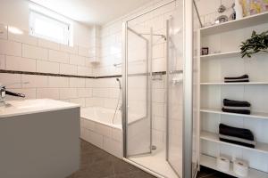 a white bathroom with a shower and a sink at Plätzchen im Grünen in Owingen +28 photos