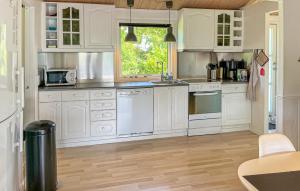 a kitchen with white cabinets and white appliances at 3 Bedroom Nice Home In Hals in Hals