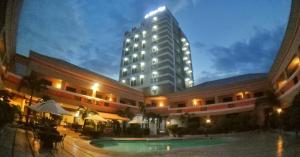 a hotel with a pool in front of a building at La Maja Rica Hotel in Tarlac