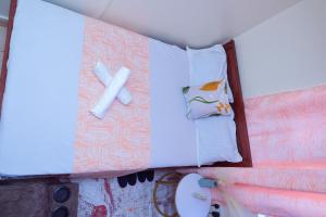 a bed with a white pillow and a teddy bear at Manta homes studio Apartments in Thika