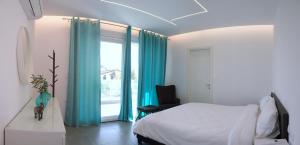 a bedroom with a bed and a window with blue curtains at Kassiani Studios in Keramoti