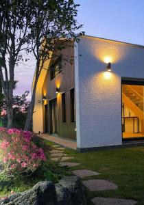 a house with a light on the side of it at Jeju Gallery House in Jeju