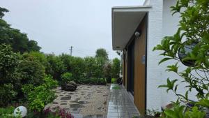 a stone walkway next to a white building at Jeju Gallery House in Jeju