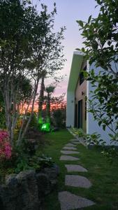 a walkway next to a building with a sunset in the background at Jeju Gallery House in Jeju