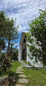 a white building with a walkway in front of it at Jeju Gallery House in Jeju +11 photos