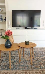 a living room with two tables and a tv at Margaréta Apartman in Balatonudvari