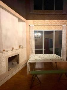 a room with a fireplace and a table with a window at Sky Star in Kazbegi +8 photos