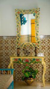 a mirror on top of a table with a plant at Maison Céline in Sousse +18 photos