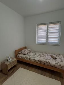 a bedroom with a bed and a window at Apartman Šarenac in Bileća