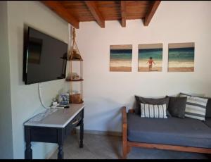 a room with a desk and a tv and a couch at La casa di Kapo in Syvota