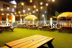 a group of picnic tables with umbrellas on a patio at Donghae Gloria Pension in Donghae +2 photos