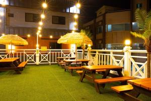 a row of wooden tables and umbrellas on a patio at Donghae Gloria Pension in Donghae