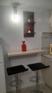 a kitchen with two stools and a counter with a shelf at Arena's nest in Áyioi Dhéka +25 photos