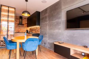 a kitchen and dining room with a table and blue chairs at Apartament 20 in Mysłowice
