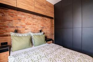 a bedroom with a bed and a brick wall at Apartament 20 in Mysłowice +13 photos