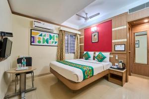 a hotel room with a bed and a television at Treebo ESS Grande in Coimbatore +31 photos