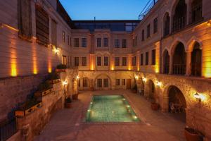 a courtyard with a swimming pool in a building at Grand Cappadocia Hotel in Göreme