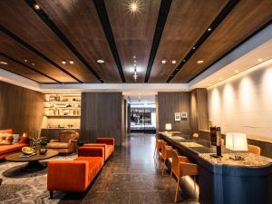 eine Lobby mit orangefarbenen Stühlen und einer Bar in einem Hotel in der Unterkunft CHECK inn SELECT Chiayi RenAi in Chiayi
