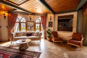 a living room with a couch and a tv at Grand Cappadocia Hotel in Göreme