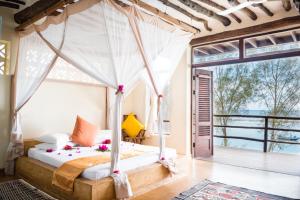 a bed room with a canopy and a canopy bed at Sunshine Marine Lodge in Matemwe