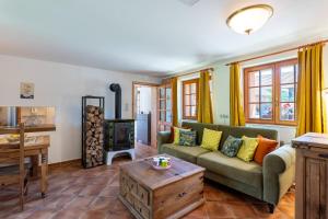 a living room with a couch and a wood stove at WELLNESS FARMHOUSE Monínec in Měšetice