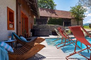 a group of chairs sitting on a deck next to a pool at WELLNESS FARMHOUSE Monínec in Měšetice