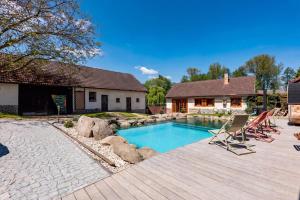 a backyard with a swimming pool and a house at WELLNESS FARMHOUSE Monínec in Měšetice