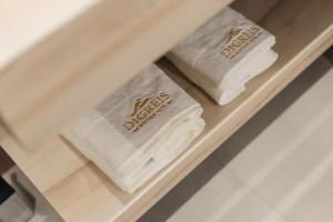 three folded towels are sitting on a shelf at Hotel Digreis in Vlorë +74 photos
