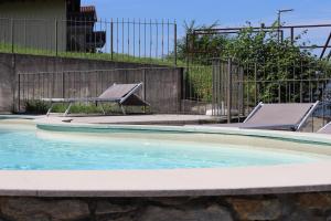 a swimming pool with a bench and a picnic table at Casa Juliette in Bellano
