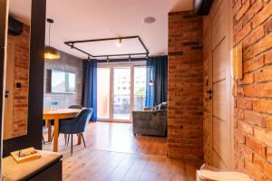 a room with a brick wall and a table and chairs at Apartament 20 in Mysłowice