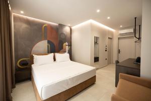 a bedroom with a bed and a painting on the wall at Hotel Digreis in Vlorë