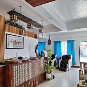 a living room with blue curtains and a bar at Mayon Lodging House in Legazpi