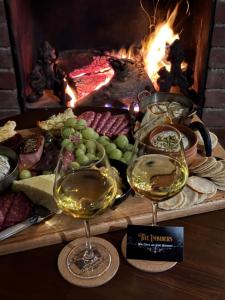 two glasses of white wine next to a fireplace at Robinson Cottage in Oatlands