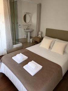 a bedroom with a large bed with two towels on it at La Canopée in La Gouesnière